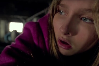 Becca (Olivia DeJonge) crawls under a house in The Visit (2015) while something follows behind.